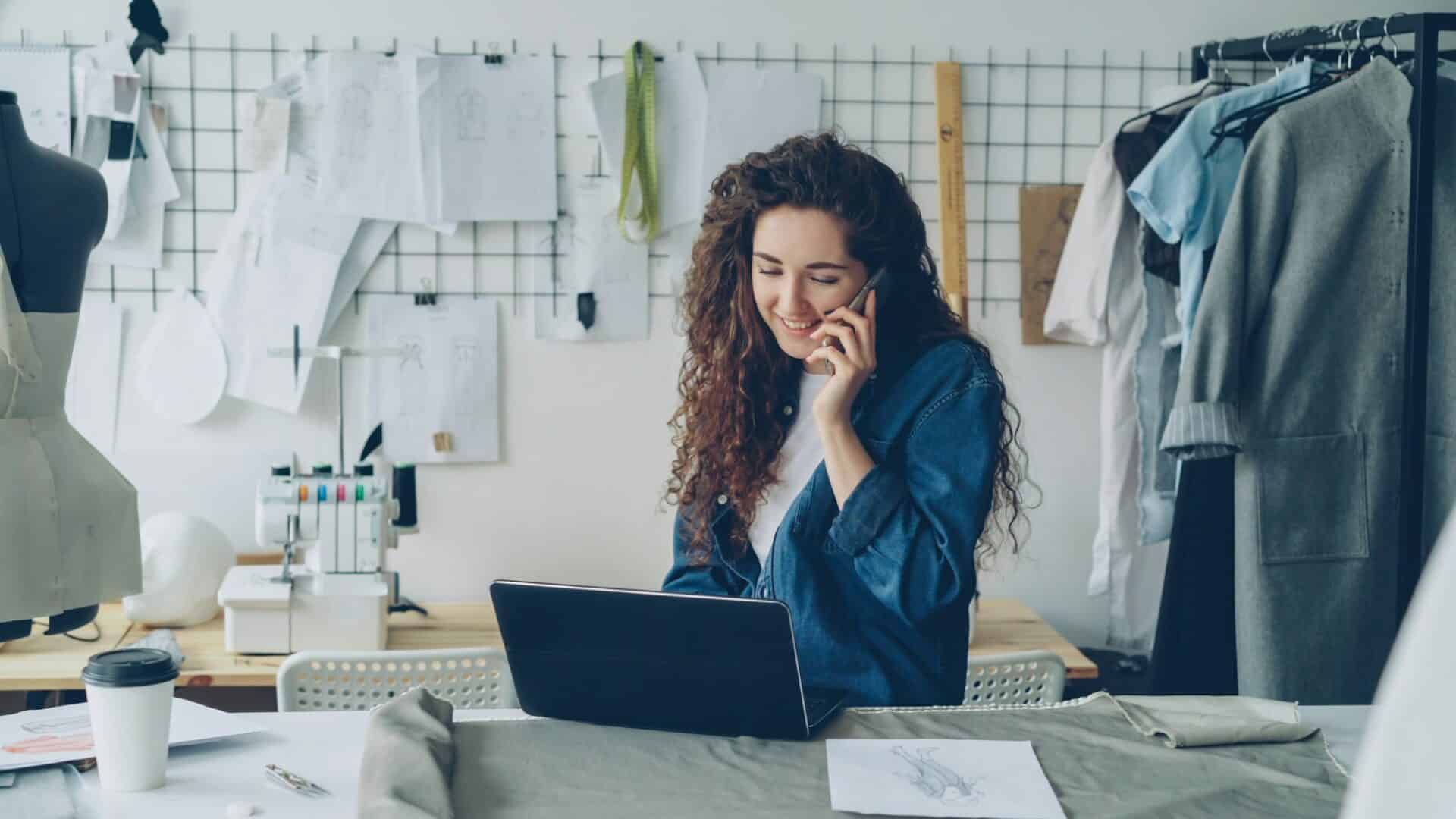 Micro-entrepreneure dans son atelier de couture, au téléphone devant son ordinateur portable